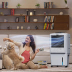 Woman sitting on a couch with a dog, next to a portable air conditioner in a living room.